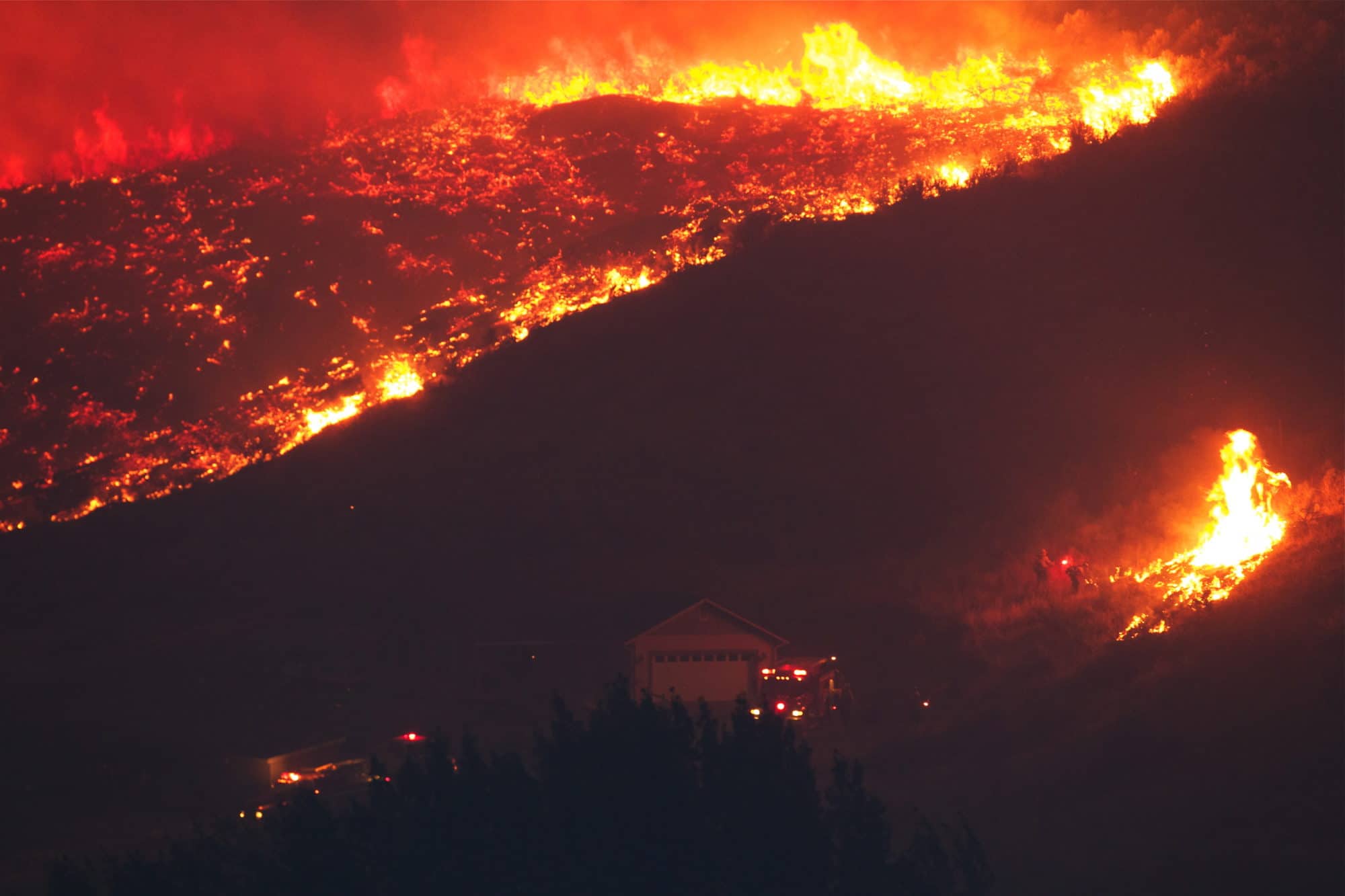 Hill in Flammen und Ersthelfer versuchen, es zu löschen