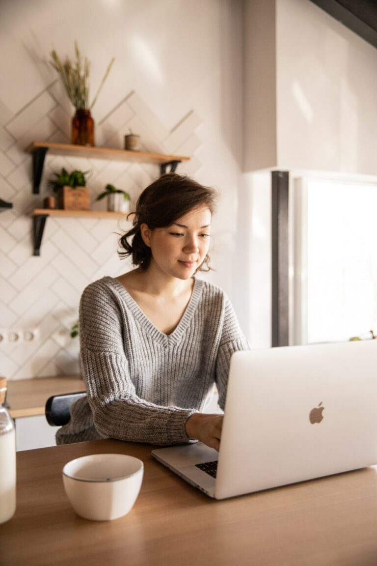 lady in her dining room on her laptop with coffee