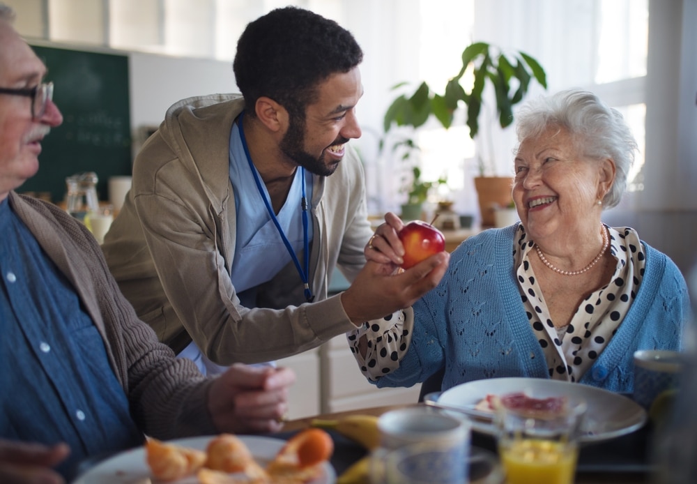 Smiling,Elderly,Woman,And,Man,Enjoying,Breakfast,In,Nursing,Home