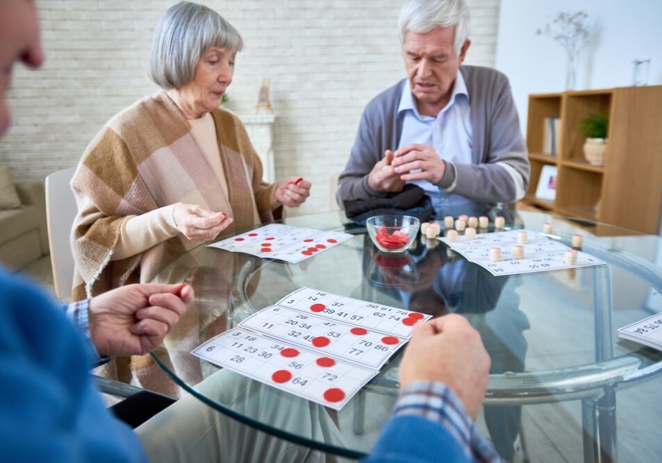 Senior,Patients,Of,Assisted,Living,Home,Gathering,At,Table,In