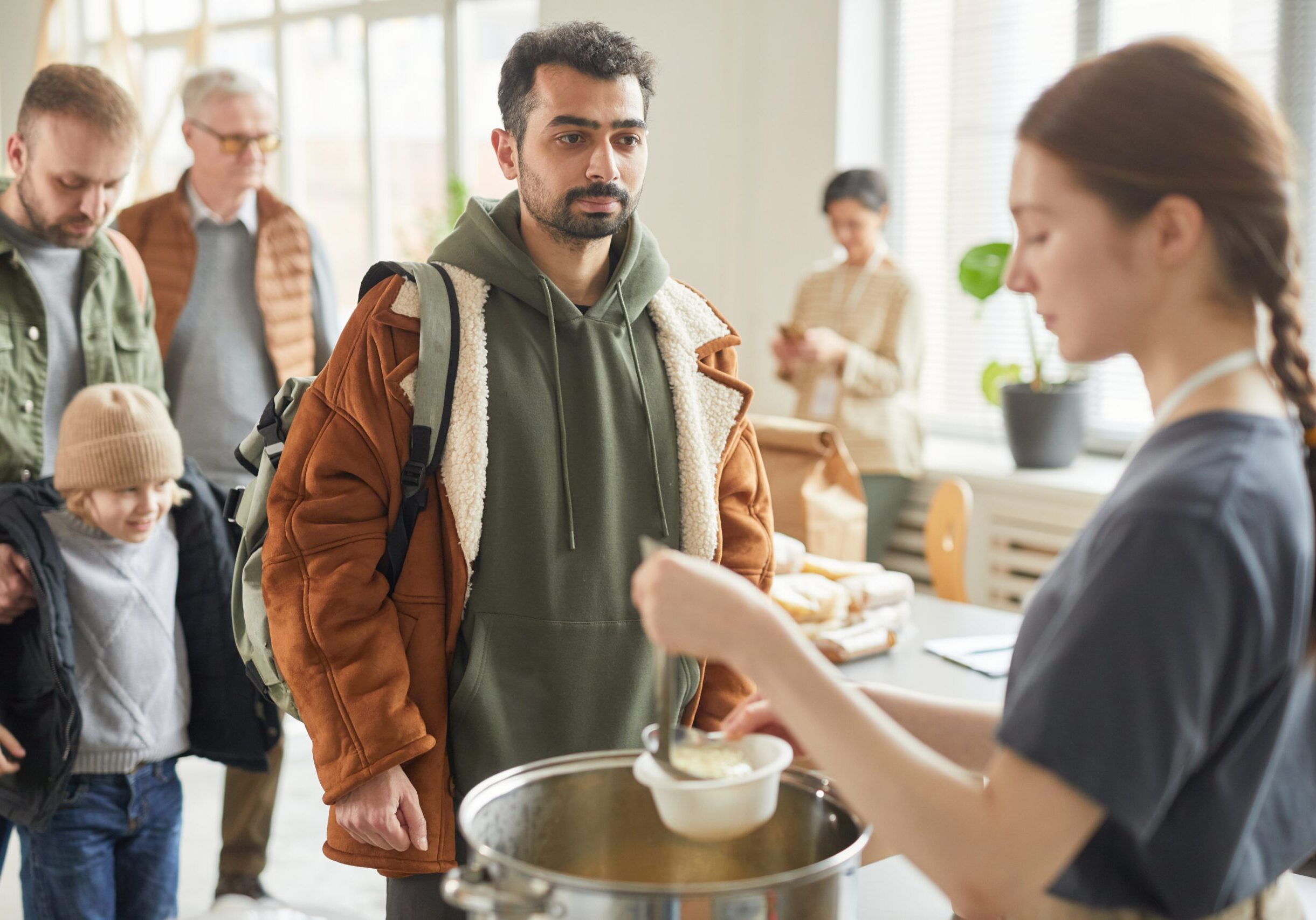 Portrait,Of,Young,Man,Standing,In,Line,At,Soup,Kitchen
