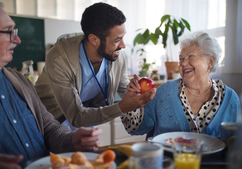 Smiling,Elderly,Woman,And,Man,Enjoying,Breakfast,In,Nursing,Home
